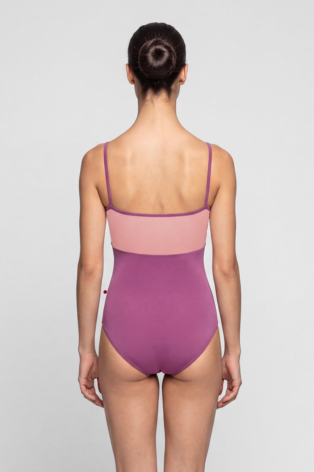 AI-generated model. Denise leotard, pink crushed-velvet bodice and a magenta body, scoop neck with thin straps.