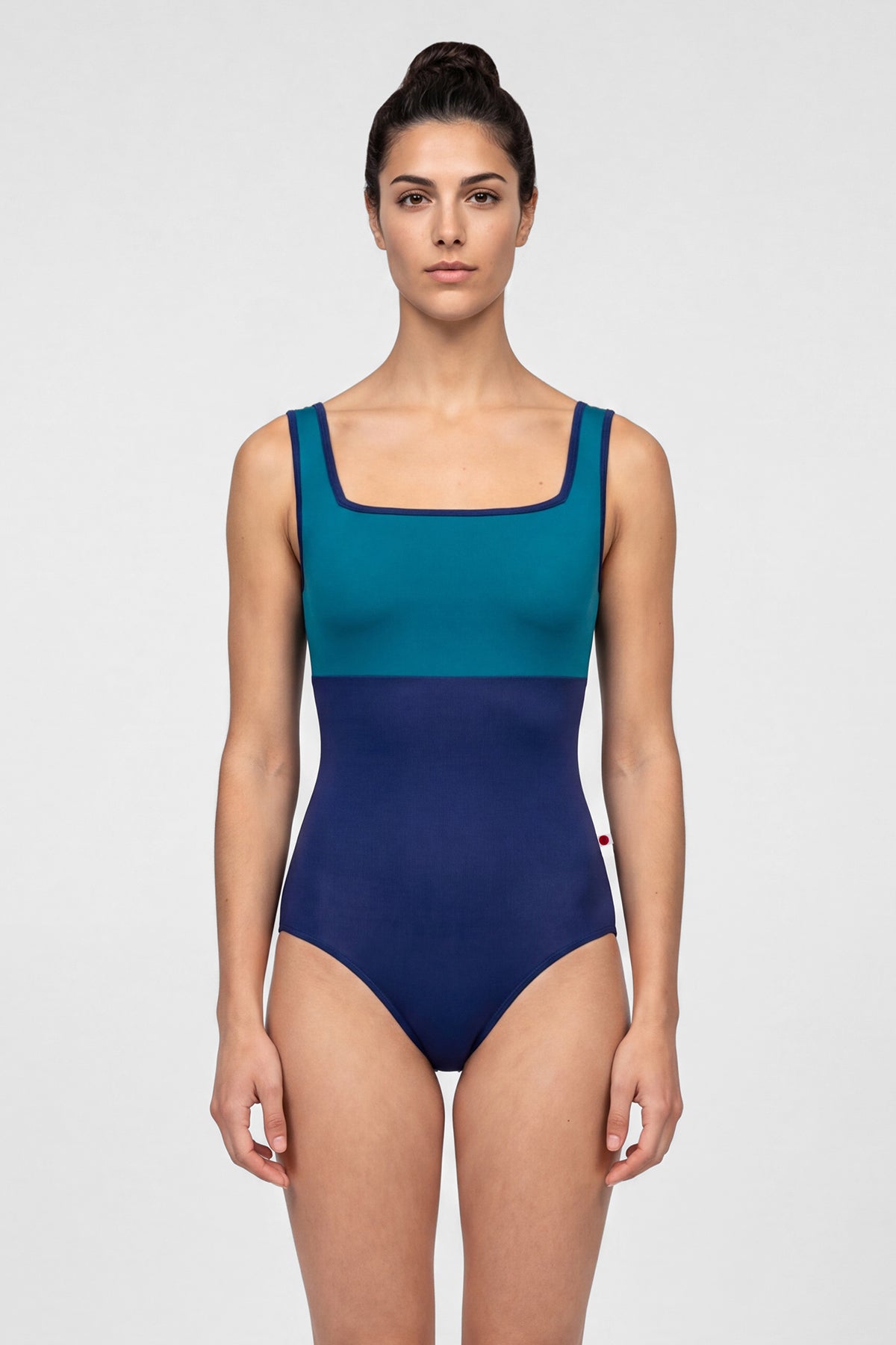 AI-generated model. Marieke leotard, teal square-neck bodice and a navy body with navy trim.