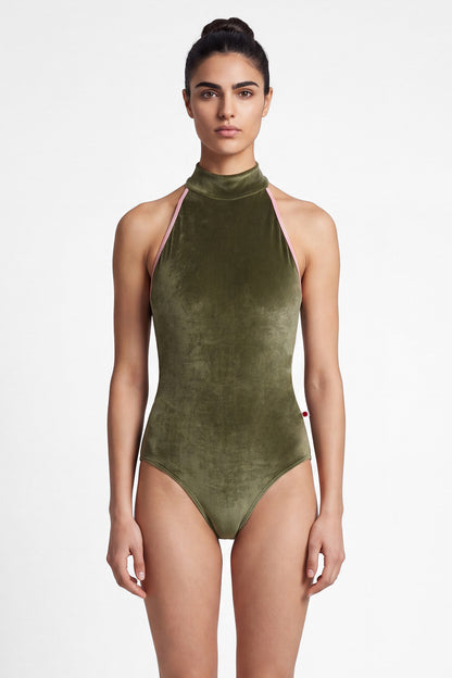 AI-generated model. Noe leotard, olive-green velvet with a high halter neck and pink strap trim, open back.