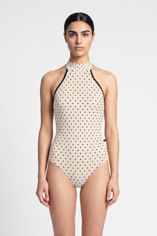 AI-generated model. Kelly leotard, all-over T-Lunares Cream polka-dot with a black-trimmed high halter neck and open sides.