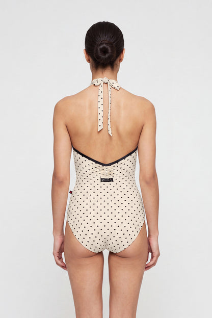 AI-generated model. Kelly leotard, all-over T-Lunares Cream polka-dot with a black-trimmed high halter neck and open sides.
