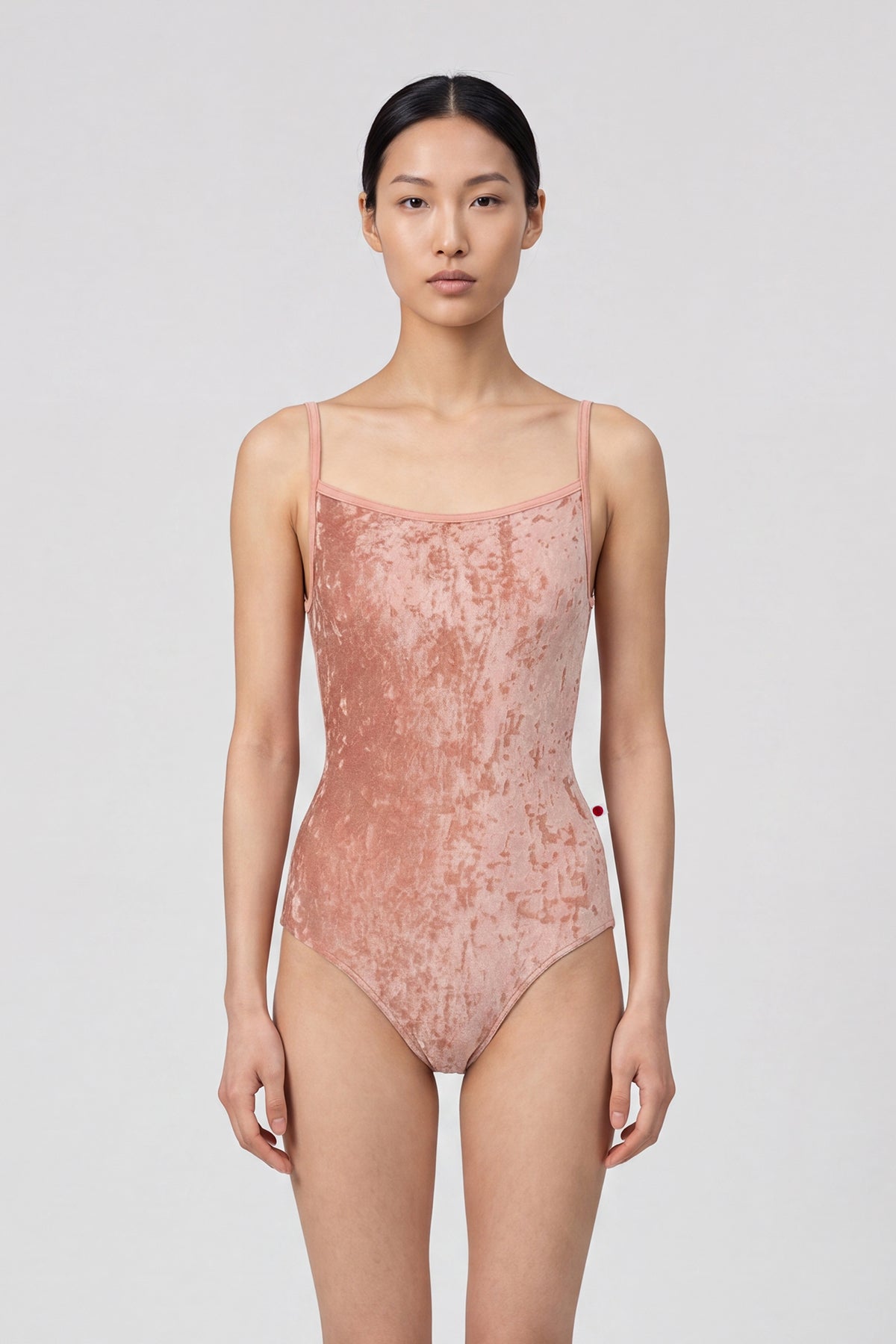 AI-generated model. Daniela leotard, all-over dusty-rose crushed velvet with a scoop neck and thin straps.