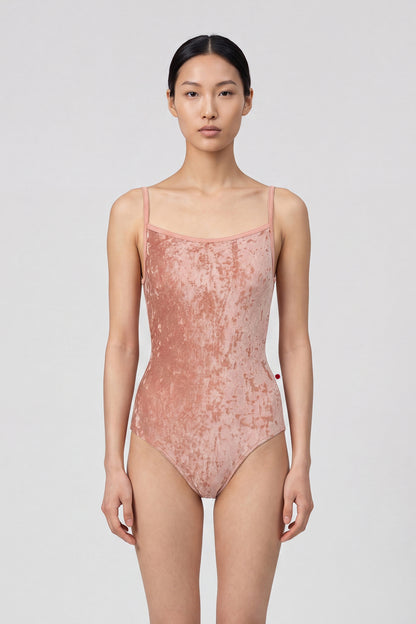 AI-generated model. Daniela leotard, all-over dusty-rose crushed velvet with a scoop neck and thin straps.