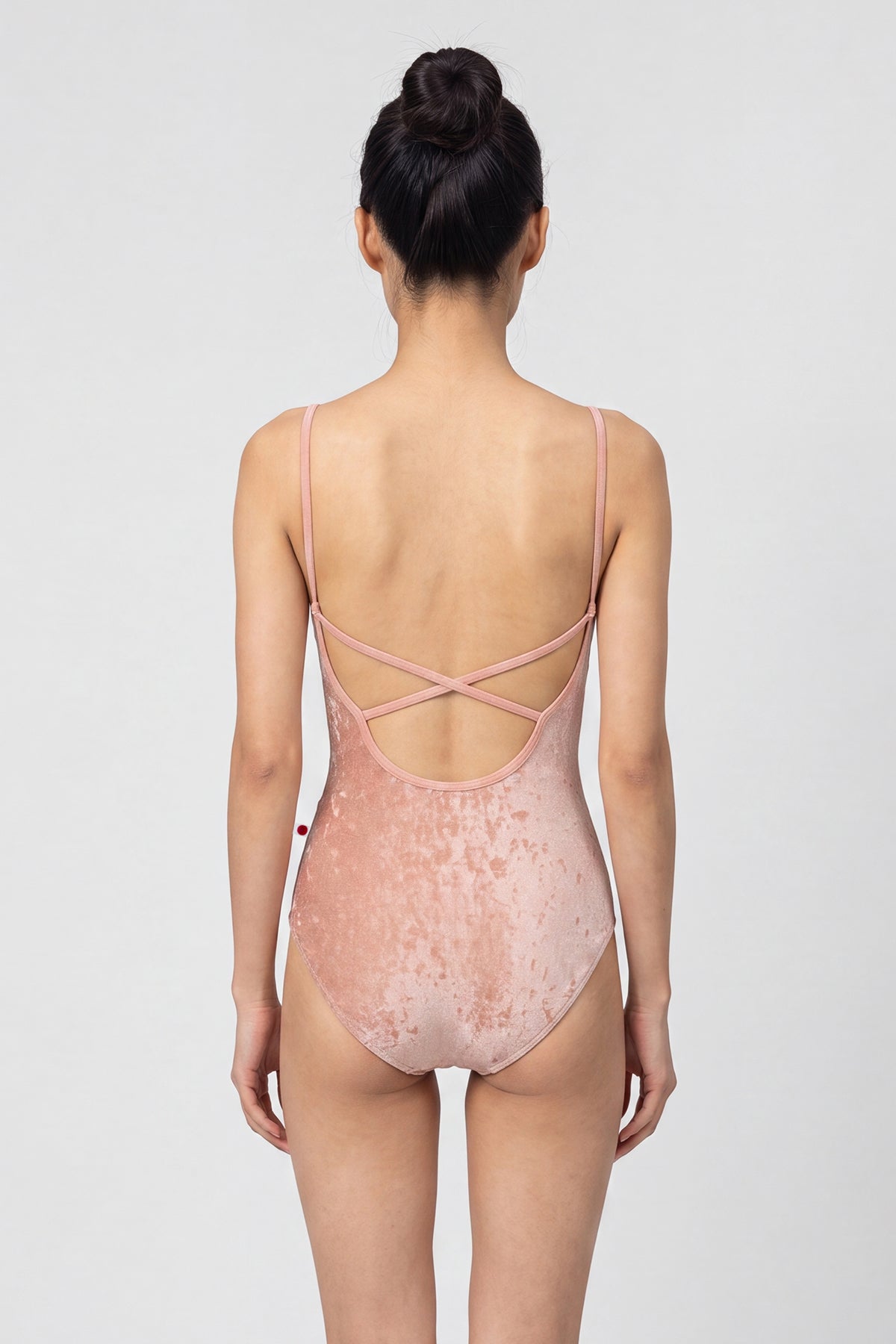 AI-generated model. Daniela leotard, all-over dusty-rose crushed velvet with a scoop neck and thin straps.