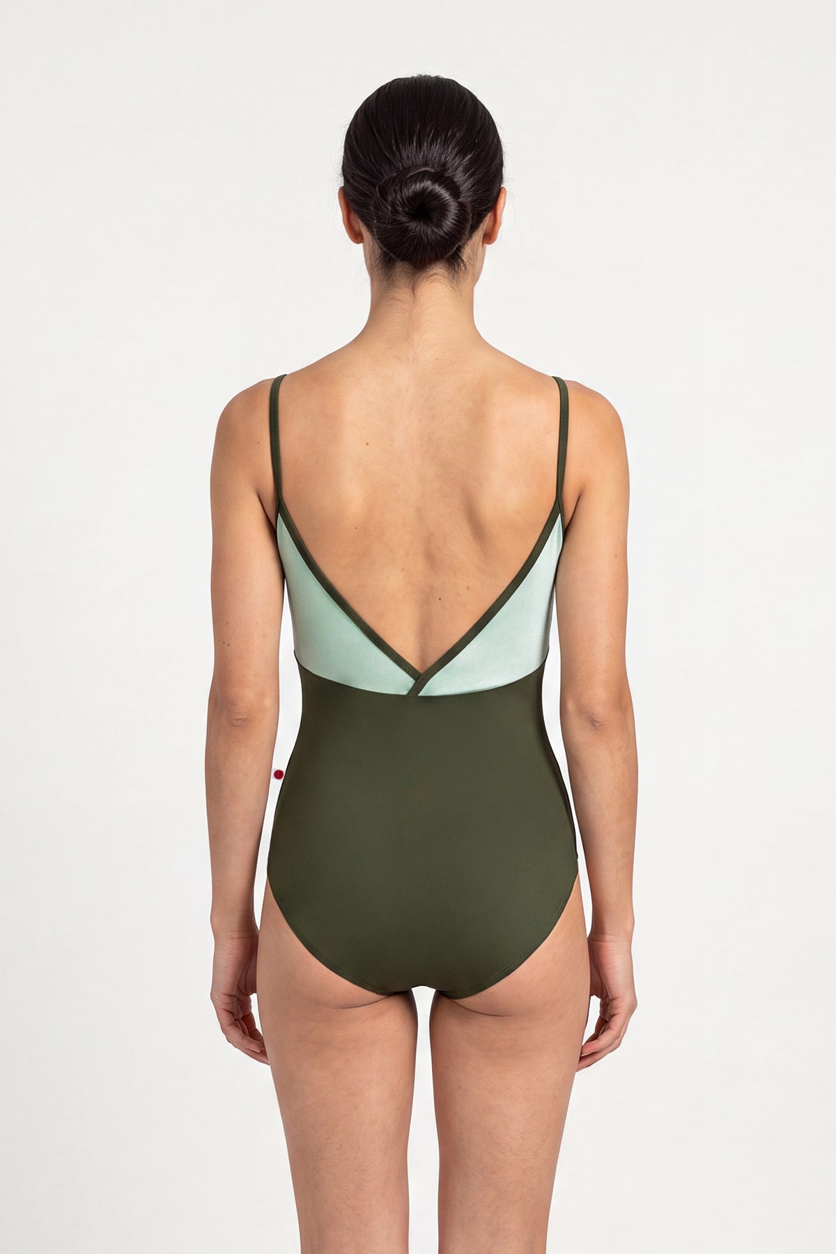 AI-generated model. Daria leotard, mint crushed-velvet bodice and an olive-green body, V-neck with thin olive straps.