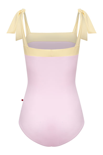 Mimi leotard, dusty pink body with a pale-yellow top band and knotted tie shoulder straps, square neckline.