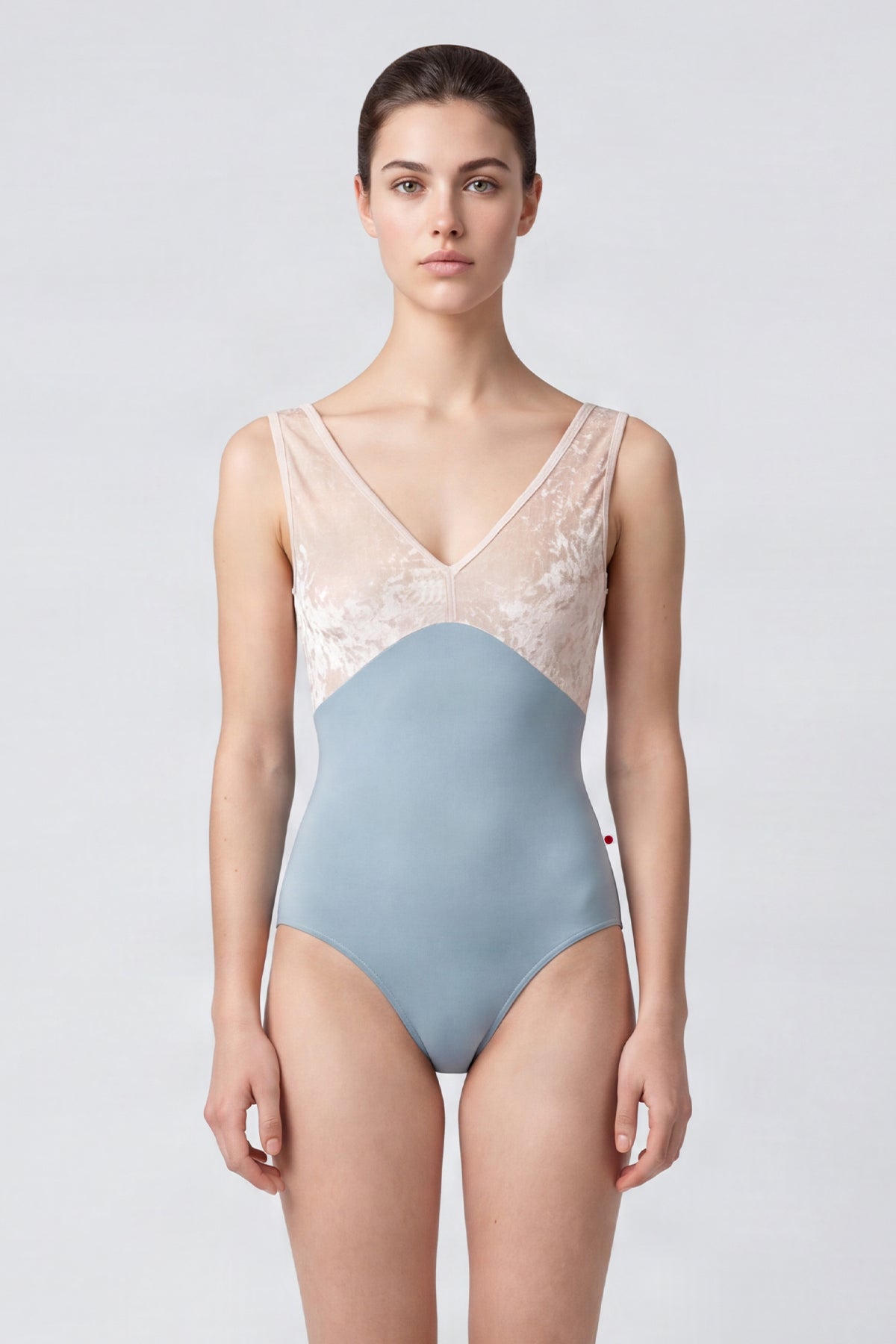 AI-generated model. Alicia leotard, blush crushed-velvet V-neck bodice and a dusty-blue body, wide straps.