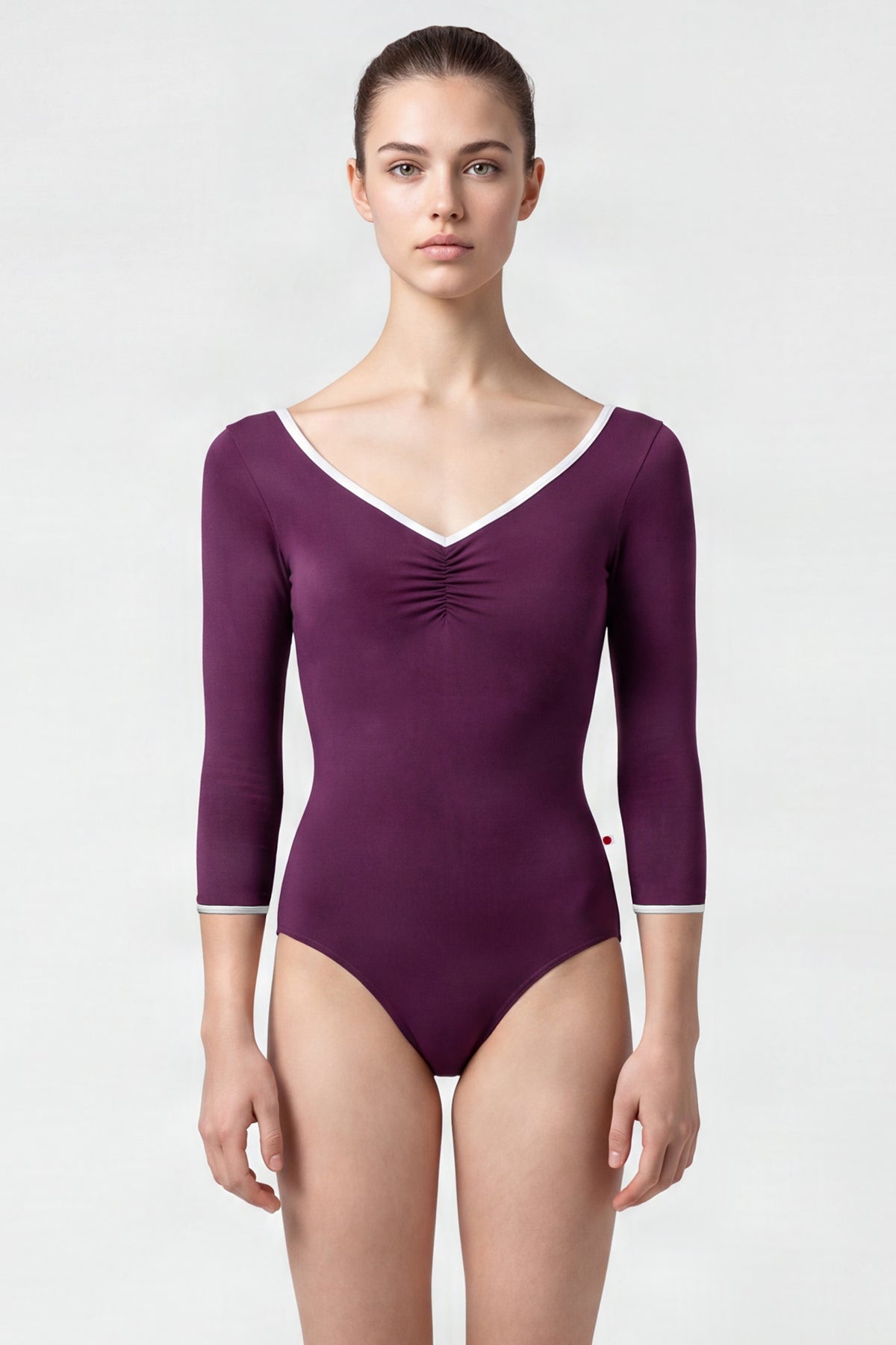 AI-generated model. Anna leotard, aubergine-purple with a ruched V-neck, silver trim and three-quarter sleeves.